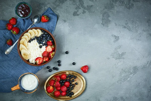 kase çilek, muz, reçel ve ekşi krema, taze meyveler ve yazlık Kahvaltı, yatay süzme peynir. yukarıdan bir yemekler gıda ile karanlık beton fon, boşaltmak.