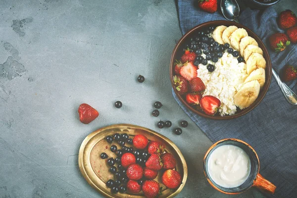 kase çilek, muz ve ekşi krema, taze meyveler ve yazlık Kahvaltı, yatay süzme peynir. karanlık beton zemin üzerinde bir yemek Gıda ile üstten görünüm
