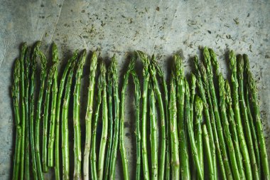 Tuz, biber ve yağ ile Taze yeşil Kuşkonmaz mızrak ızgara veya pişirme kağıdı üzerinde kavrulmuş hazır. Pişirme için kuşkonmaz, üst görünümü. Yemek pişirme
