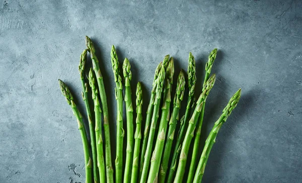 gri beton zemin üzerine taze çiğ Bahçe kuşkonmaz demet. Yemek pişirmek için malzemeler. Gıda arka plan. Kopya alanı ile üstten görünüm.