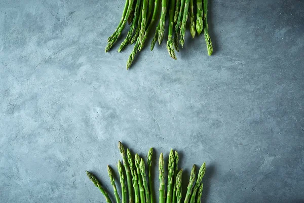 gri beton arka plan üzerinde taze ham bahçe kuşkonmaz iki demet. Yemek pişirmek için malzemeler. Yemek geçmişi. Kopyalama alanı ile üstte görünüm.