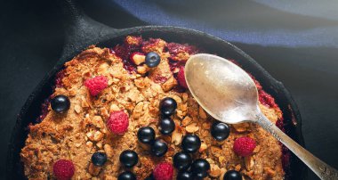 Yaz kahvaltısı. koyu taş masada siyah dökme demir kızartma tavada yaban mersini ile ufalamak. Üstte görüntü