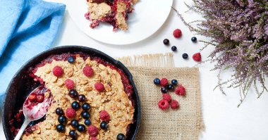 Yaz kahvaltı. beyaz masa üzerinde siyah dökme demir tavada yaban mersini ile harap. Üstten görünüm