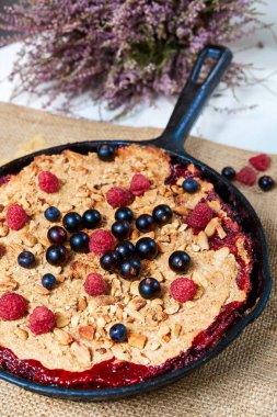 Yaz kahvaltı. beyaz masa üzerinde siyah dökme demir tavada yaban mersini ile harap. Üstten görünüm