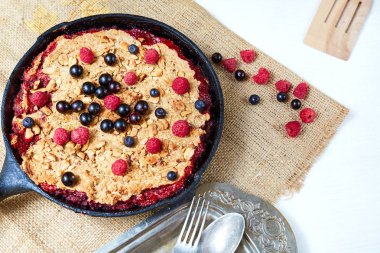 Yaz kahvaltı. beyaz masa üzerinde siyah dökme demir tavada yaban mersini ile harap. Üstten görünüm