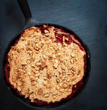 Yaz kahvaltısı. koyu taş masada siyah dökme demir kızartma tavada yaban mersini ile ufalamak. Üstte görüntü