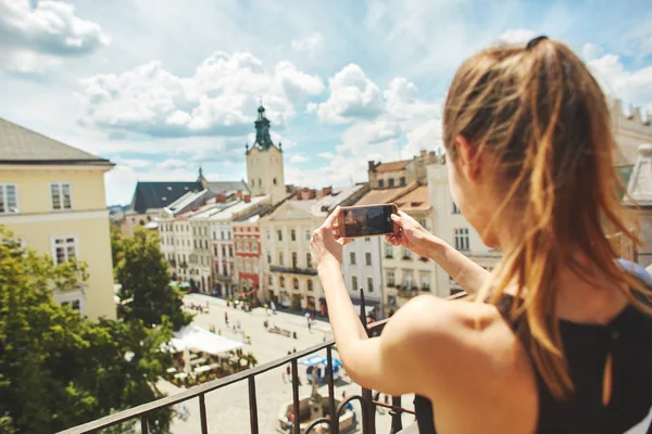 Joven turista haciendo la foto de la ciudad vieja de Lviv desde la azotea —  Fotos de Stock