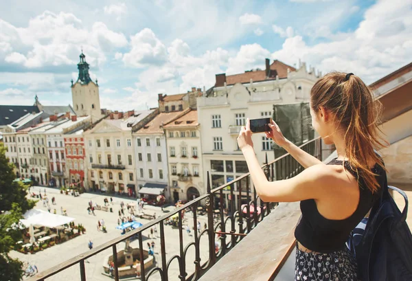 Giovane turista donna rendendo la foto della città vecchia di Leopoli dal tetto — Foto Stock