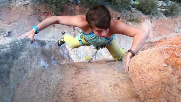 Kvinnlig bergsklättrare klättrar på klippan — Stockvideo