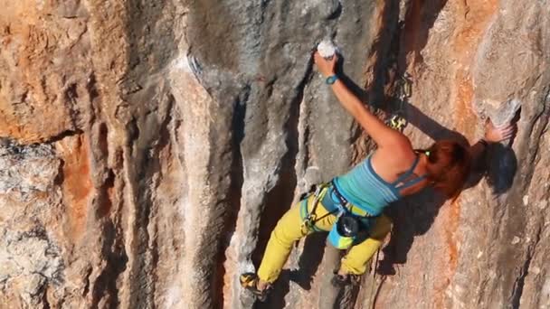 Mujer escaladora escalando en el acantilado — Vídeo de stock