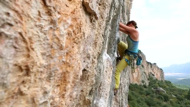 Bergsteigerin klettert auf Klippe — Stockvideo