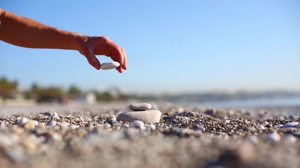 Kiezels op het strand zee close-up en mans hand — Stockvideo