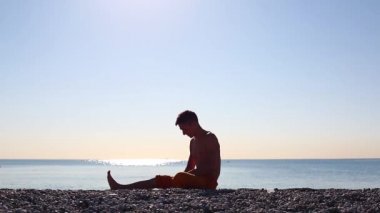 Genç bir adam şafak tanışır ve deniz sahilde Yoga yapar