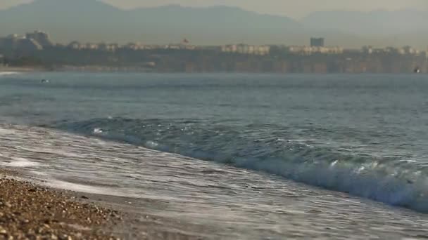 Hullámai roll a Kavicsokat a tengerparton — Stock videók