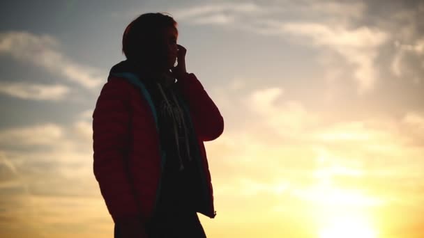 Молода жінка зустрічає схід сонця на морському пляжі — стокове відео