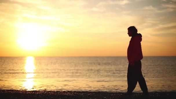 Jovem mulher está encontrando nascer do sol na praia do mar — Vídeo de Stock