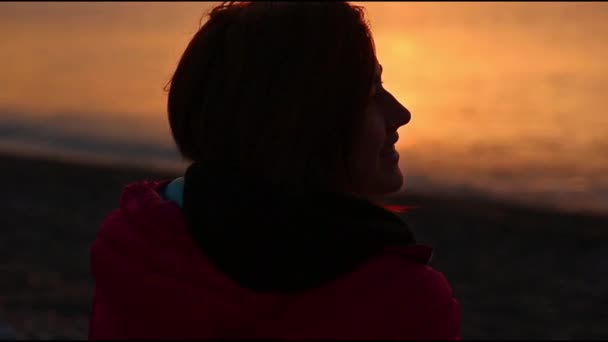 Silhouet van een jonge vrouw vergadering dageraad op het zee-strand — Stockvideo