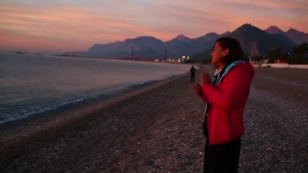 Молода жінка зустрічає світанок на морському пляжі — стокове відео