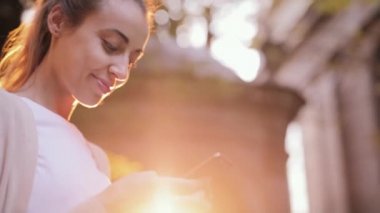 Sırasında cep telefonu yürü sokaklarda kullanarak çekici genç kadın