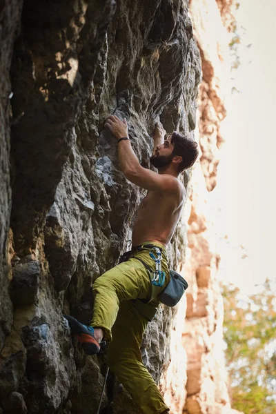 Klippklättring. man rock klättrare klättrar utmanande rutten på den steniga väggen — Stockfoto