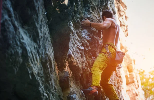 Klippklättring. man rock klättrare klättrar utmanande rutten på den steniga väggen — Stockfoto