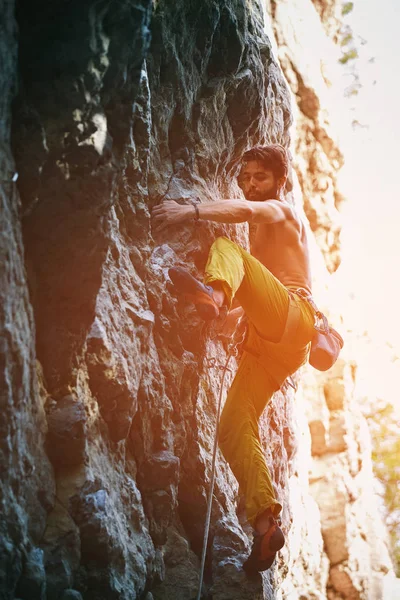 Klippklättring. man rock klättrare klättrar utmanande rutten på den steniga väggen — Stockfoto