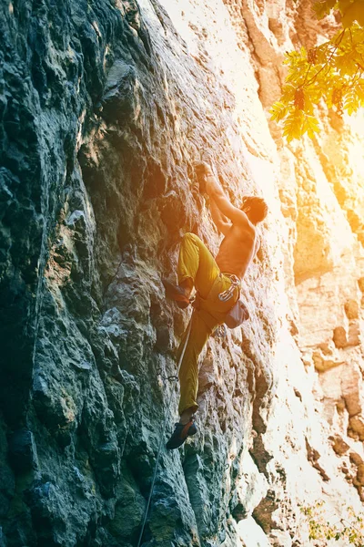 Klippklättring. man rock klättrare klättrar utmanande rutten på den steniga väggen — Stockfoto