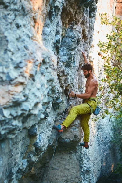 Klippklättring. man rock klättrare klättrar utmanande rutten på kalksten väggen — Stockfoto