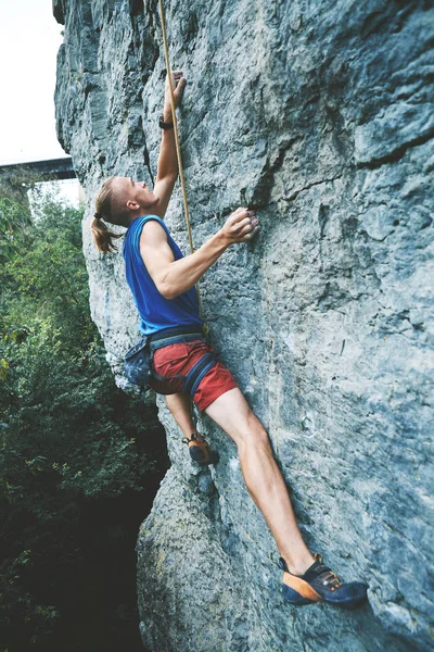 Klettern. Bergsteiger erklimmt die anspruchsvolle Route an der Kalksteinwand — Stockfoto