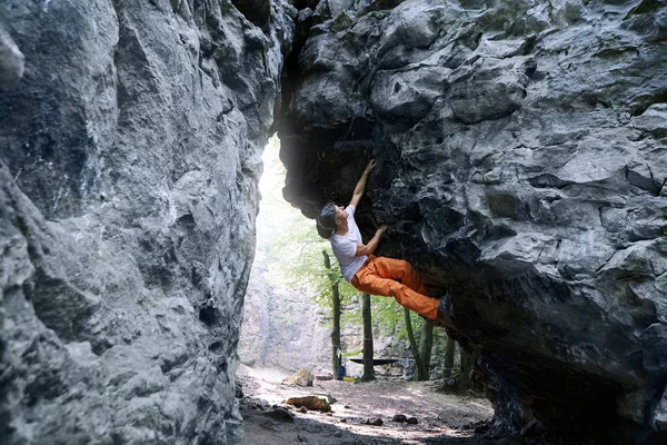 Uomo arrampicatore arrampicatore sulla scogliera strapiombante — Foto Stock