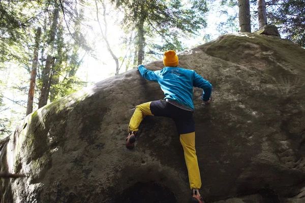En man rock klättrare klättrar en sten ute i skogen — Stockfoto
