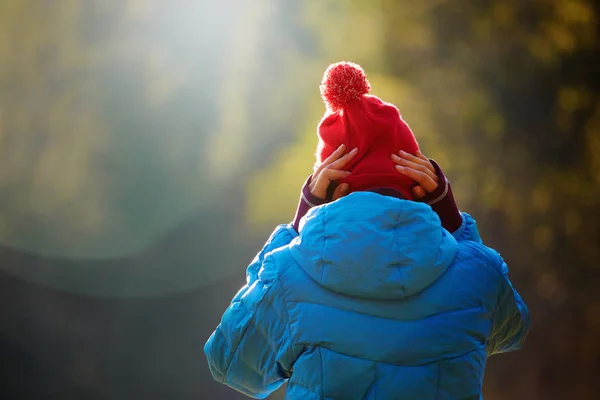 Mujer en una chaqueta azul y gorra roja está de pie en el bosque de otoño — Foto de Stock