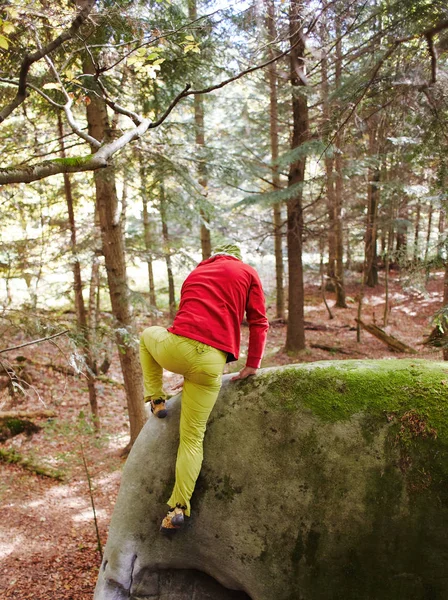 Un arrampicatore uomo arrampicando una roccia all'aperto nella foresta — Foto Stock