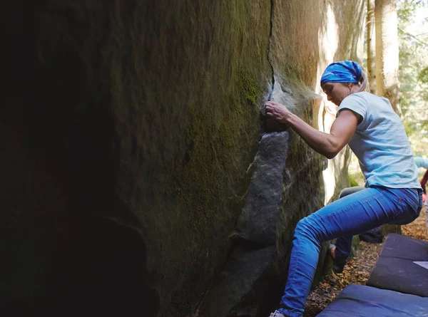 Kobieta arywista wspinaczki skały na zewnątrz w lesie — Zdjęcie stockowe