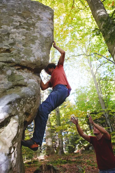 Skalisty arywista człowiek wspinaczki skały i jego partner, ubezpieczenia. — Zdjęcie stockowe