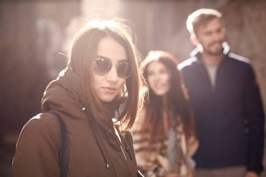 Mutlu çift geçmişinde siyah güneş gözlüklü üzgün yalnız kadın. Üçüncü tekerlek. Aşk üçgeni. Terk edilmiş yalnız kadın