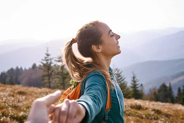 Onnellinen houkutteleva nainen vaellus seisoo vuoren rinteellä taustaa vasten auringonlaskun — kuvapankkivalokuva