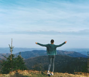 gün batımı arka plana karşı Dağ sırtının kenarında kadın otostopçu ayakta