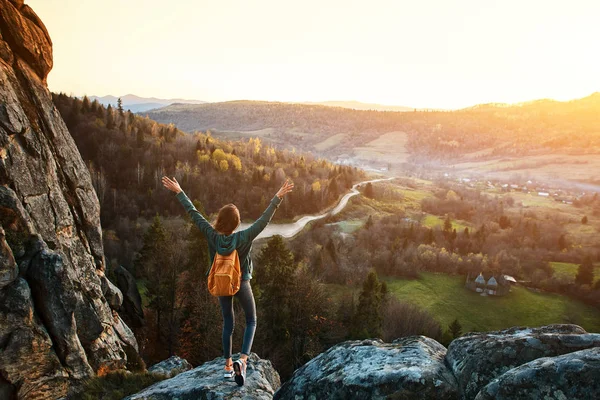 kadın gündoğumu arka plana karşı uçurumun kenarına duruyor