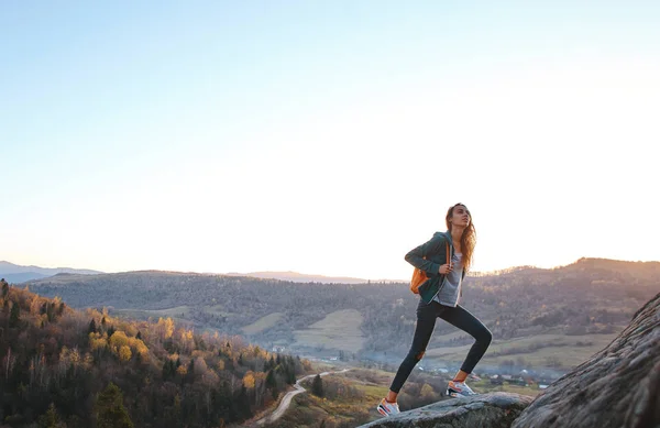 Femme marchant sur le bord de la falaise sur fond de lever du soleil — Photo