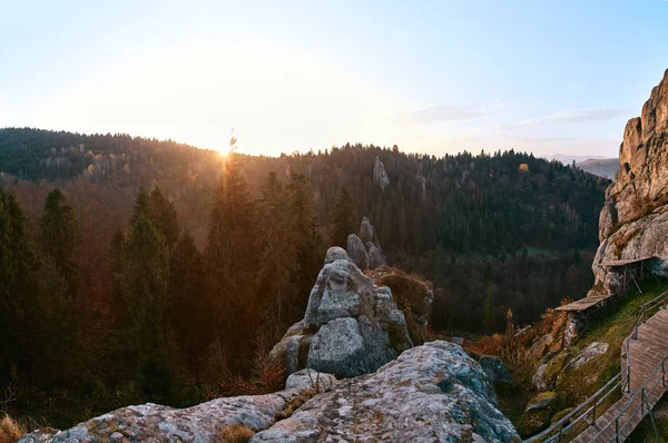 Soloppgang i nasjonalparken over skog og stein. Den stigende solen lyser vakkert opp toppen av furuene og fjellryggen. – stockfoto