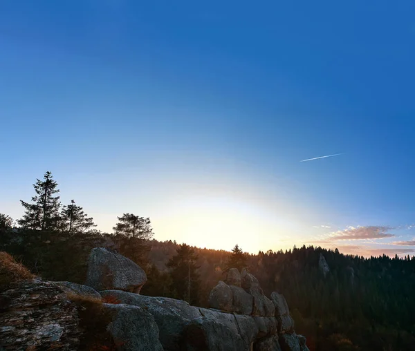 Sunrise in national park over forest and rocks. the rising sun beautifully illuminates the tops of the pines and the rock ridge — Stock Photo, Image