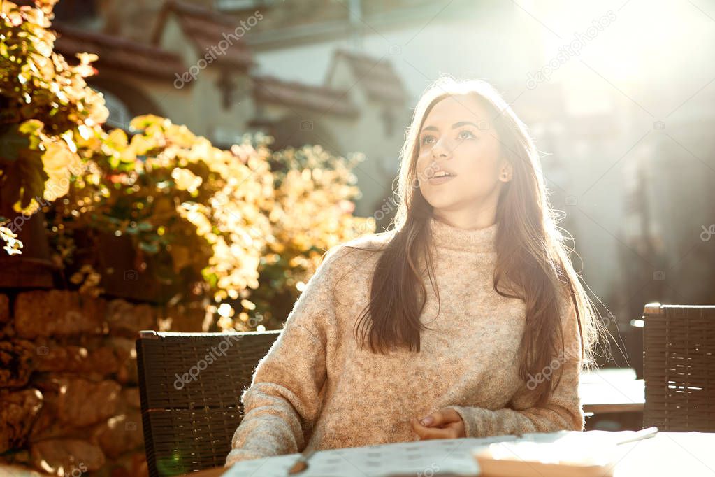 beautiful woman sitting in the street cafe in the central part of city