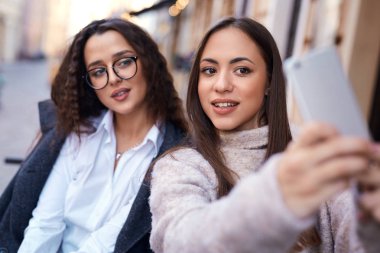 iki güzel kadın şehir orta kısmında telefonla selfie yapma
