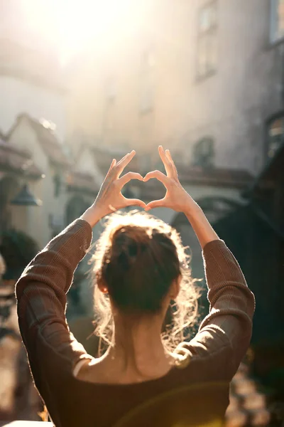 beautiful young woman shows heart with fingers