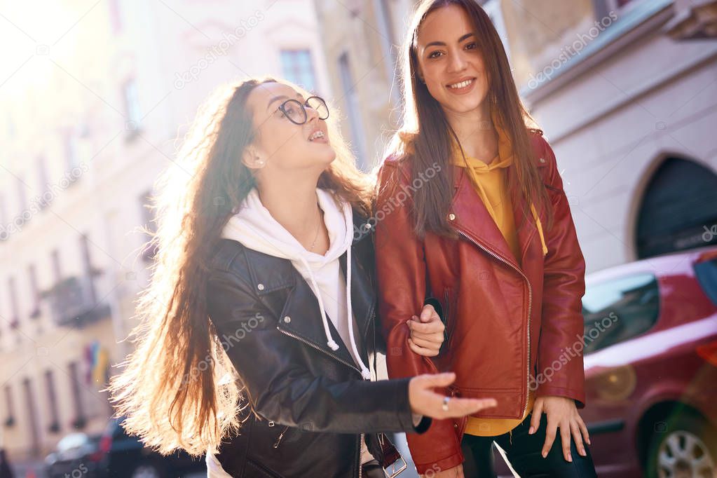 two young girls walking on city street having fun