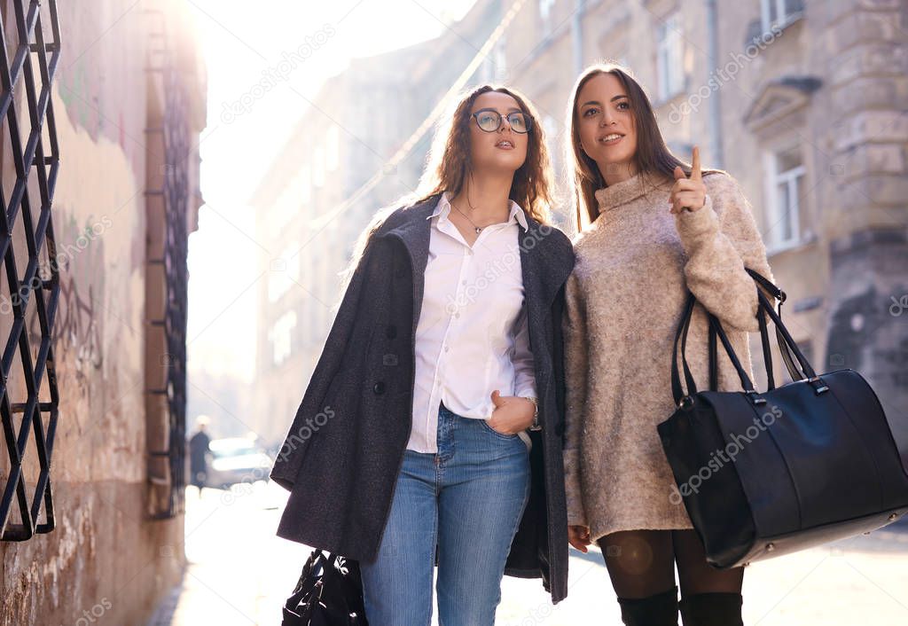 two beautiful fashionable women walking in the city