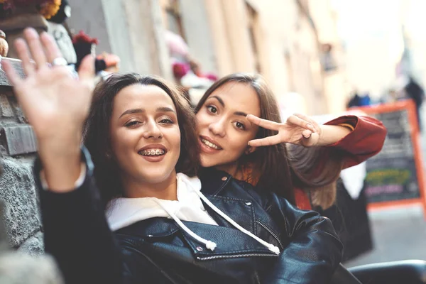 Twee jonge vrolijke meisjes glimlachend en gebaren naar de camera — Stockfoto