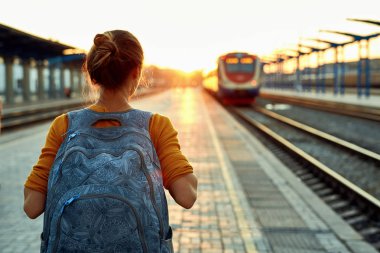 bir genç kadın seyahat tren stantion üzerinde küçük sırt çantası ile portresi
