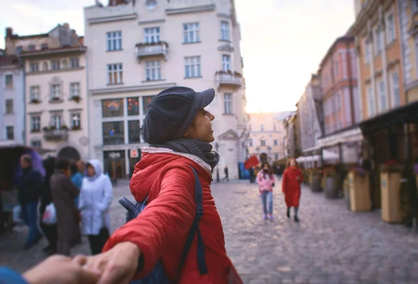 Visão em primeira pessoa da jovem mulher em casaco vermelho e chapéu cinza andando na rua — Fotografia de Stock